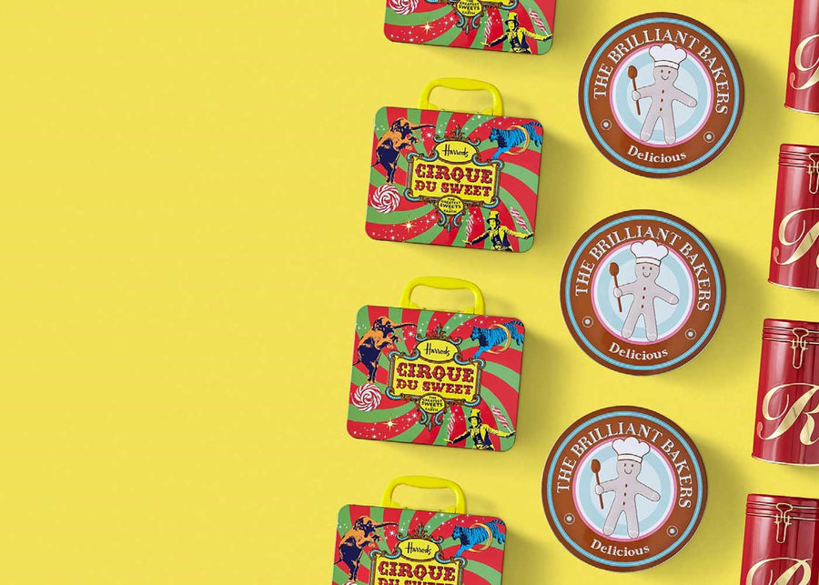 Drie verschillende soorten en vormen blikken in een lijn tegen een gele achtergrond. De metalen verpakking bevat koekjes, cake, snoep of koffie.