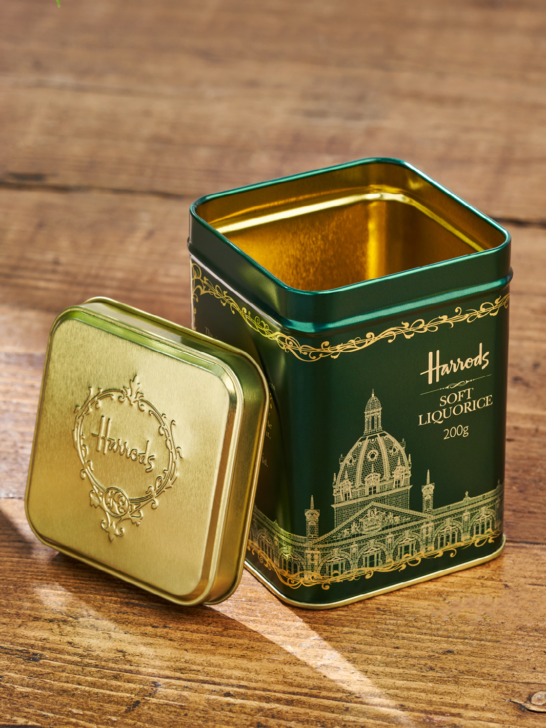 Een groen verpakkingsblik van Harrods voor snoep. Goud is geëtst in het groene ontwerp. 