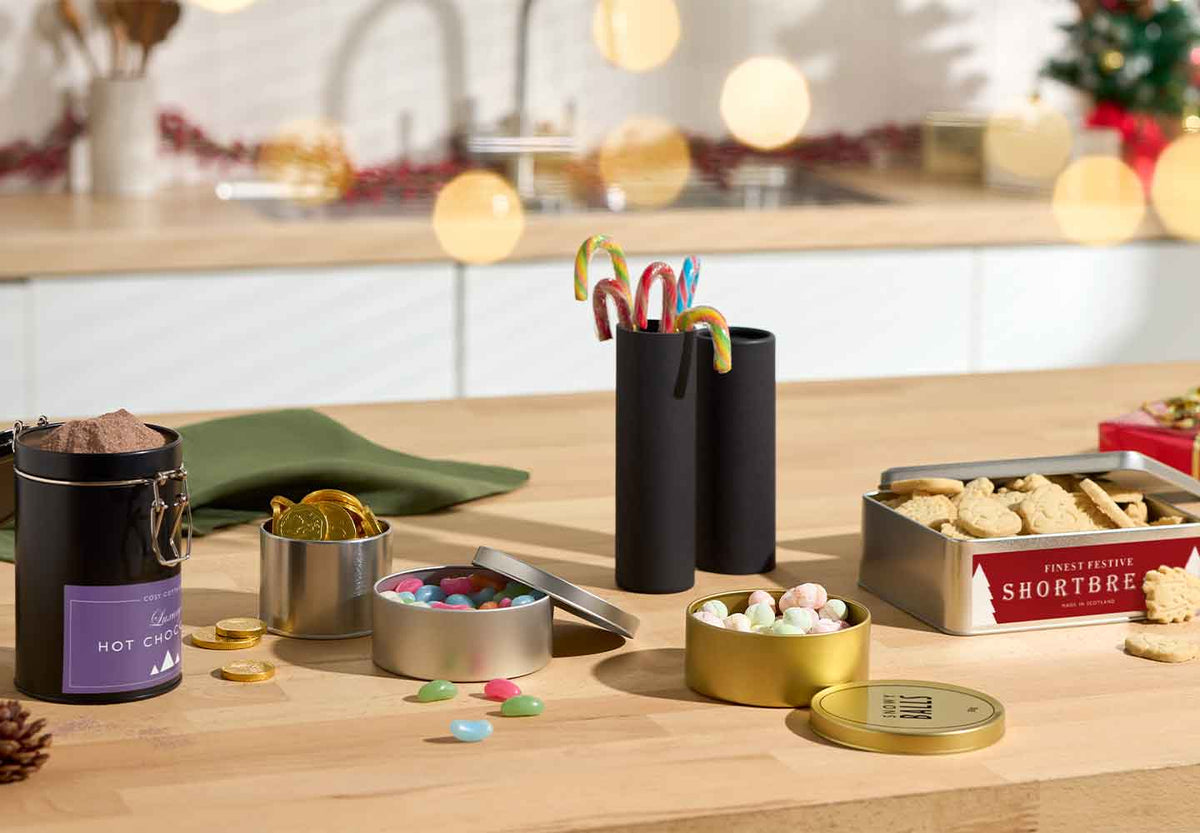 Collectie bakjes voor snoepjes in een kerstversierde keuken.
