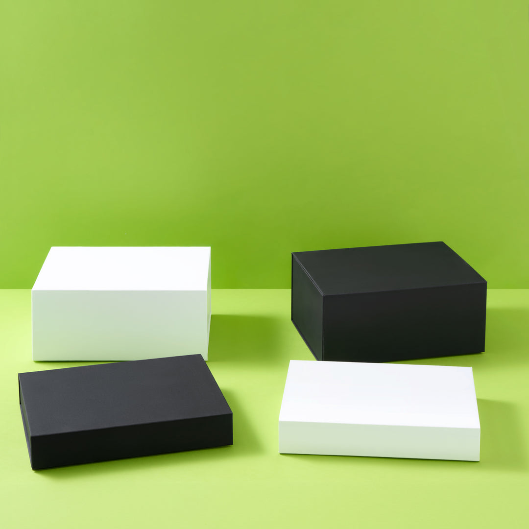 Collectie geschenkdozen in zwart en wit op een groene achtergrond
