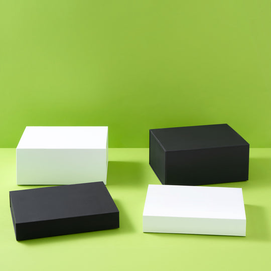 Collectie geschenkdozen in zwart en wit op een groene achtergrond
