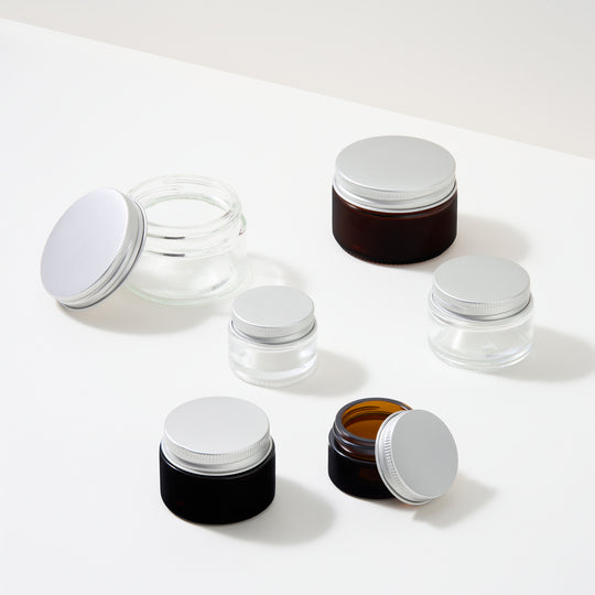 Collectie glazen cosmeticapotjes met schroefdeksels
